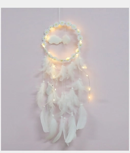 Detail of dream catcher with white daisies, clouds, feathers and warm LED light strings