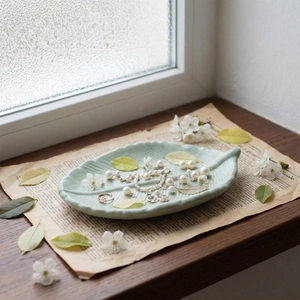 Leaf-shaped resin tray with detailed vein textures used as a decorative jewelry holder