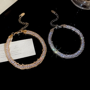 Detailed close-up of gold and silver chain bracelets with sparkling pavé cubic zirconia
