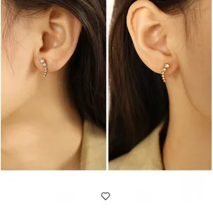 Macro detail of curved gold earrings with gradient white zircon stones in side profile