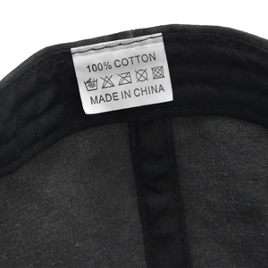 Detailed macro view of the 100% cotton inner lining and care label on the black cap
