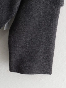 Close-up of dark grey wool knit fabric texture and sleeve cuff craftsmanship