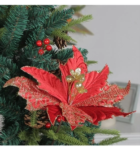 Close-up of red velvet Christmas poinsettia with glittery gold edges and floral details