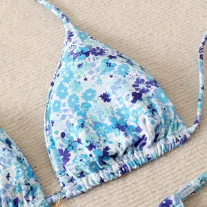 Close-up of blue floral bikini top with ruffled triangle cups and halter neck detail