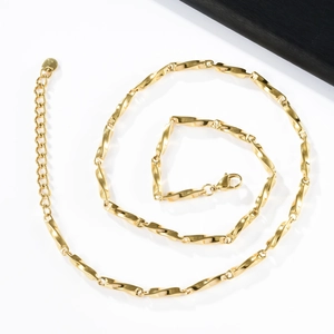 Golden Möbius stainless steel necklace with twisted rectangular links on white background
