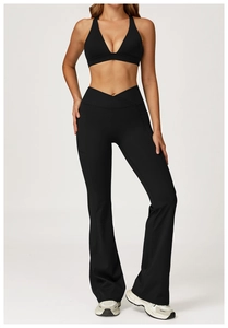 Detail of high-waist flared yoga pants with cross-waist design and side pockets in black