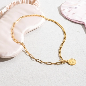 Detail of gold coin pendant necklace featuring Elizabeth II relief and mixed chain link