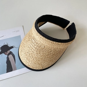 Détail d'une visière en paille de raphia avec passepoil noir et tissage en spirale