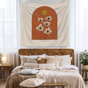 Detail of bohemian wall tapestry featuring sun and floral motifs in a cozy bedroom setting