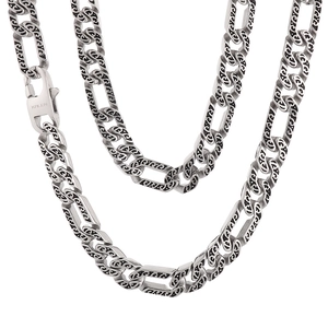 Silver stainless steel flat Cuban link necklace with intricate engraved patterns on white base