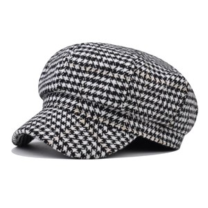 Classic black and white houndstooth newsboy cap with structured brim and round crown