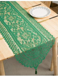 Detailed emerald green lace table runner with hollow patterns and elegant tassels