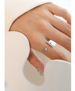 Detailed close-up of a silver T-shaped open ring on finger with elegant minimalist styling
