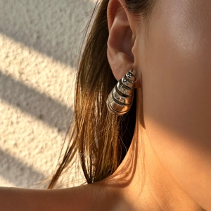 Minimalist silver spiral hollow earrings in vintage stainless steel worn in sunlight
