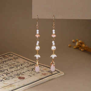 Detailed view of Chinese style butterfly earrings with pink drops and pearl tassels