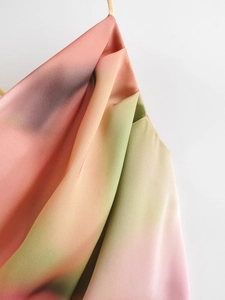 Detail of colorful gradient satin dress showing silky texture and elegant fabric draping
