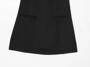 Détails d'une mini robe noire en coupe A avec poches décoratives et ourlet soigné