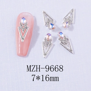 Macro shot of V-shaped alloy nail charms with teardrop iridescent stones and small rhinestones