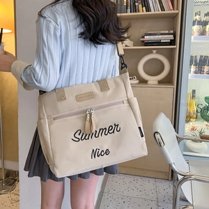 Detail of beige canvas tote bag with Summer Nice embroidery and adjustable shoulder strap