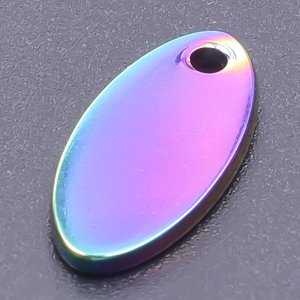 Macro shot of oval stainless steel pendant with rainbow gradient finish and cord hole