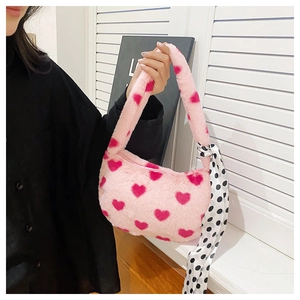 Detail of pink plush handbag with heart pattern and black white polka dot silk scarf