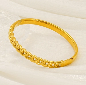 Détail d'un bracelet en acier titane doré avec surface lisse et maille torsadée