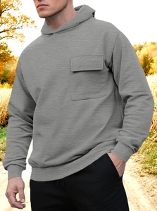 Detail of grey hoodie showing functional chest flap pocket and textured knit fabric