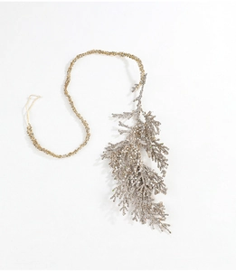 Close-up of artificial cypress branch with champagne gold glitter for Christmas decor