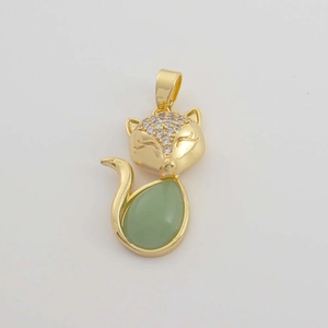 Macro shot of 18K gold fox pendant with green teardrop stone and zircon details