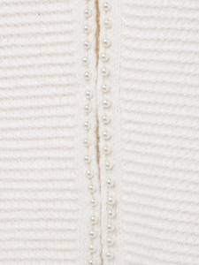 Vue macro détaillée du cardigan en maille côtelée blanche avec boutons perlés élégants