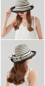 Detail view of woven straw sun hat with black stripes and elegant bow decoration
