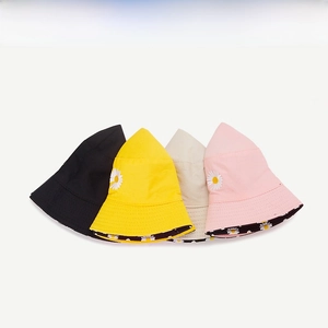 Close-up of daisy embroidery and floral print lining on colorful cotton bucket hats