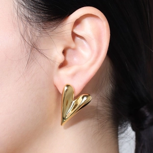 Elegant gold minimalist heart-shaped stud earring shown on a model for a stylish look