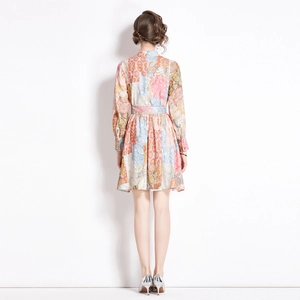 Back view of a long sleeve paisley print dress with a waist belt and vintage pleated hem