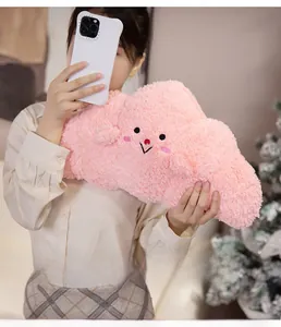 Close-up of pink cloud plush pillow with embroidered cute face and soft fabric texture