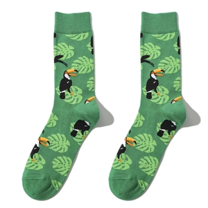 Detailed view of green crew socks featuring tropical toucan and monstera leaf patterns