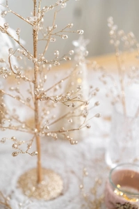 Macro shot of gold decorative tree branch with crystal beads and sparkling round base