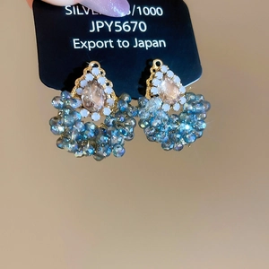 Détail de boucles d'oreilles perles avec cristal champagne et tige en argent 925