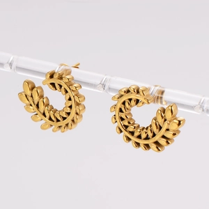 Macro shot of gold wheat leaf earrings showing detailed metallic texture and C-shape design