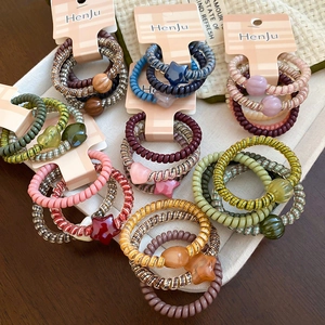 Macro shot of colorful spiral hair ties with heart and star charms on display cards
