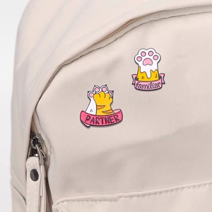 Cute cartoon cat paw enamel badges with PARTNER text on cream canvas backpack