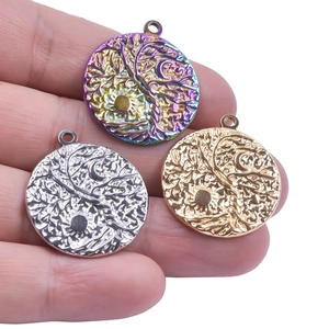 Close-up of sun, moon and tree of life pendants in rainbow, silver and gold finishes