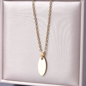 Detailed macro view of an 18k gold-plated oval pendant on an O-chain necklace