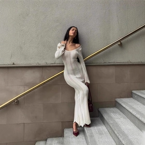 Detailed texture of off-white ribbed knit dress with elegant off-shoulder long sleeve design