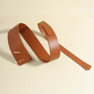 Detail of a spiraled brown leather belt showing smooth texture and flexible material