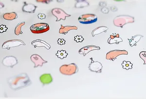 Macro detail of cartoon salmon and floral nail art stickers with frosted matte finish