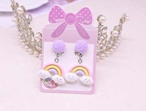 Detail of purple glitter ball clip-on earrings with rainbow and cloud resin charms