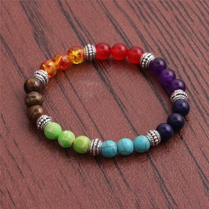 Colorful natural gemstone beads bracelet with silver alloy spacers on dark wood