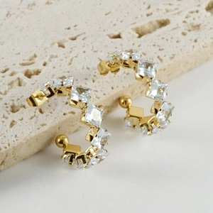 Close-up of gold C-shaped earrings with square-cut cubic zirconia and ball backings