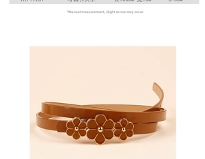 Close-up of thin brown leather belt with retro floral buckle and gold rivet details